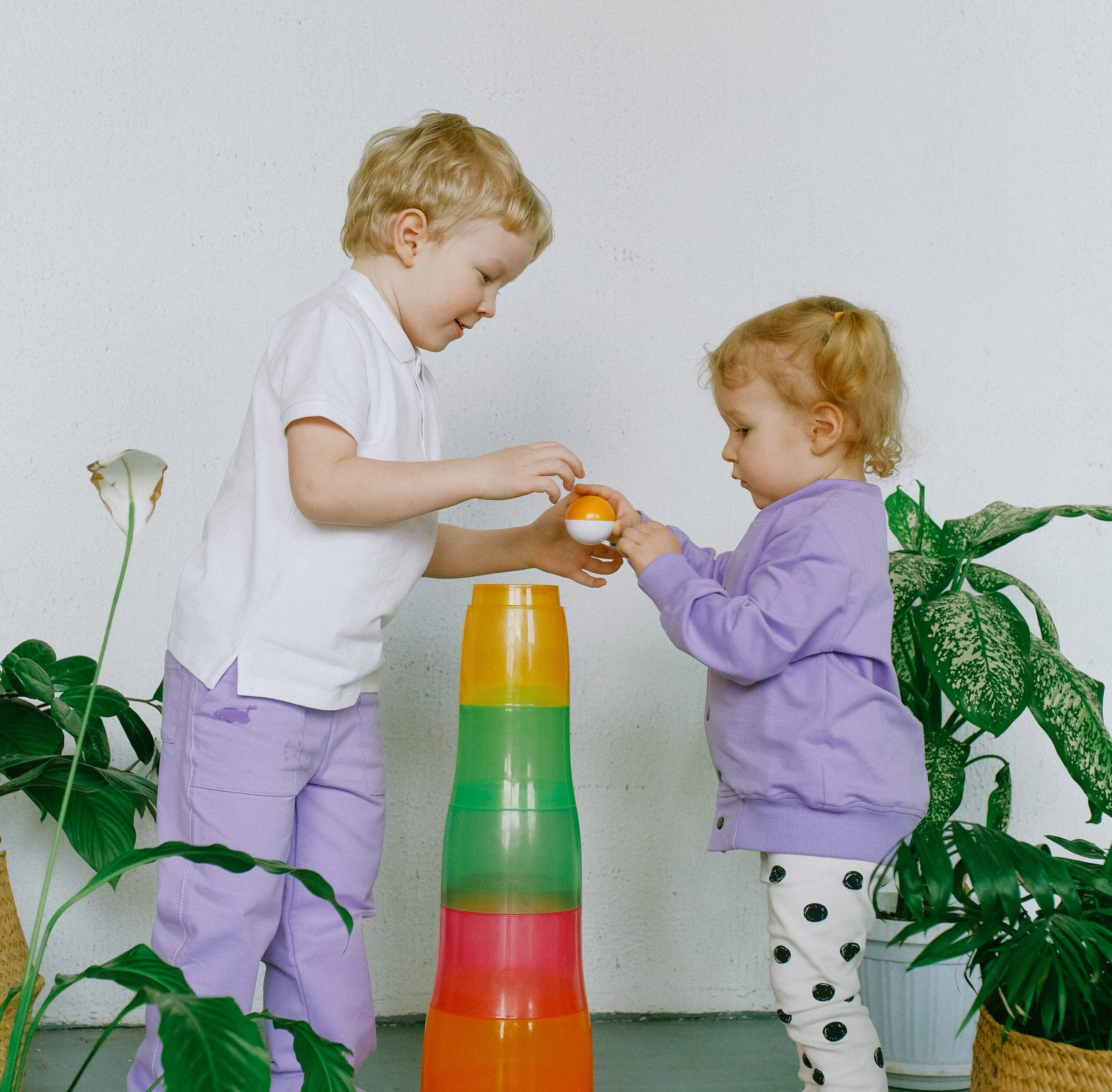 siblings sharing with their toys scaled