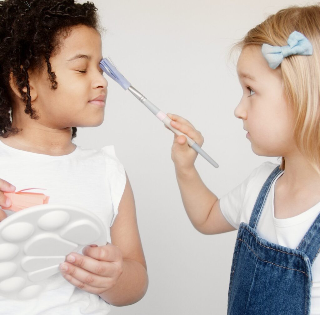 two kids holding a paintbrush and a palette